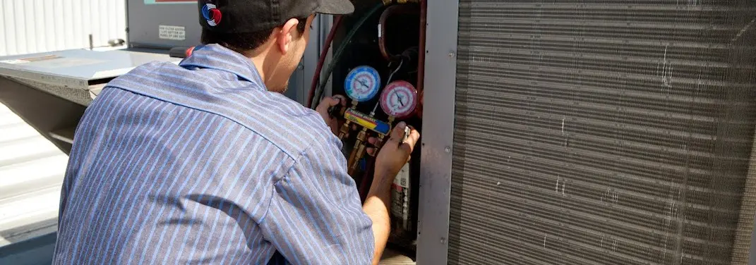 HVAC technician servicing a condenser unit in North Salem